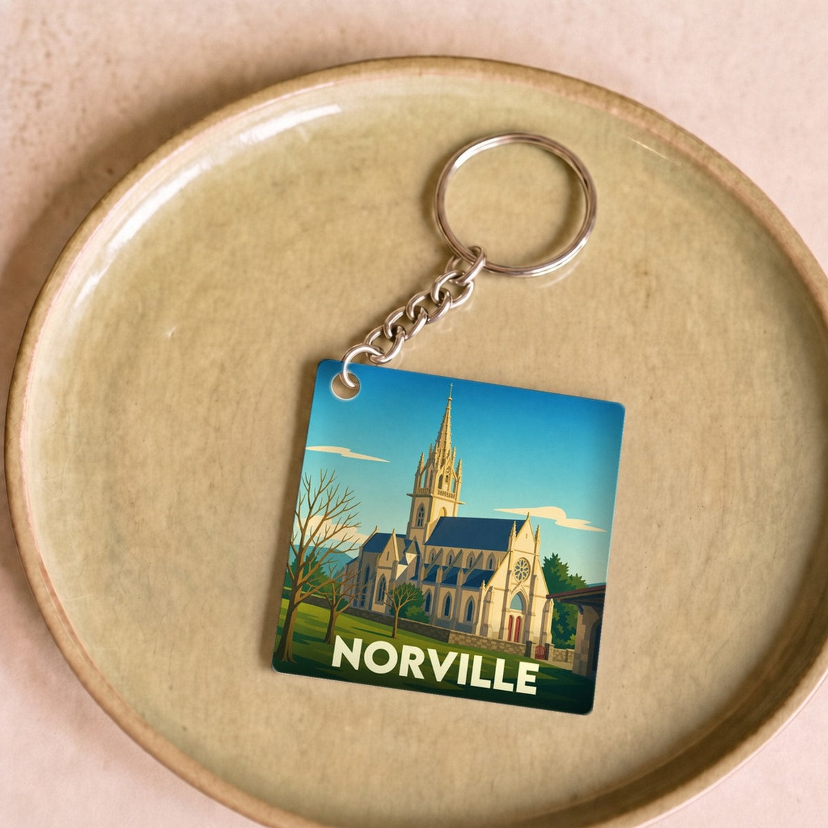Porte-clés souvenir de la ville de Norville avec une illustration stylisée de son église.