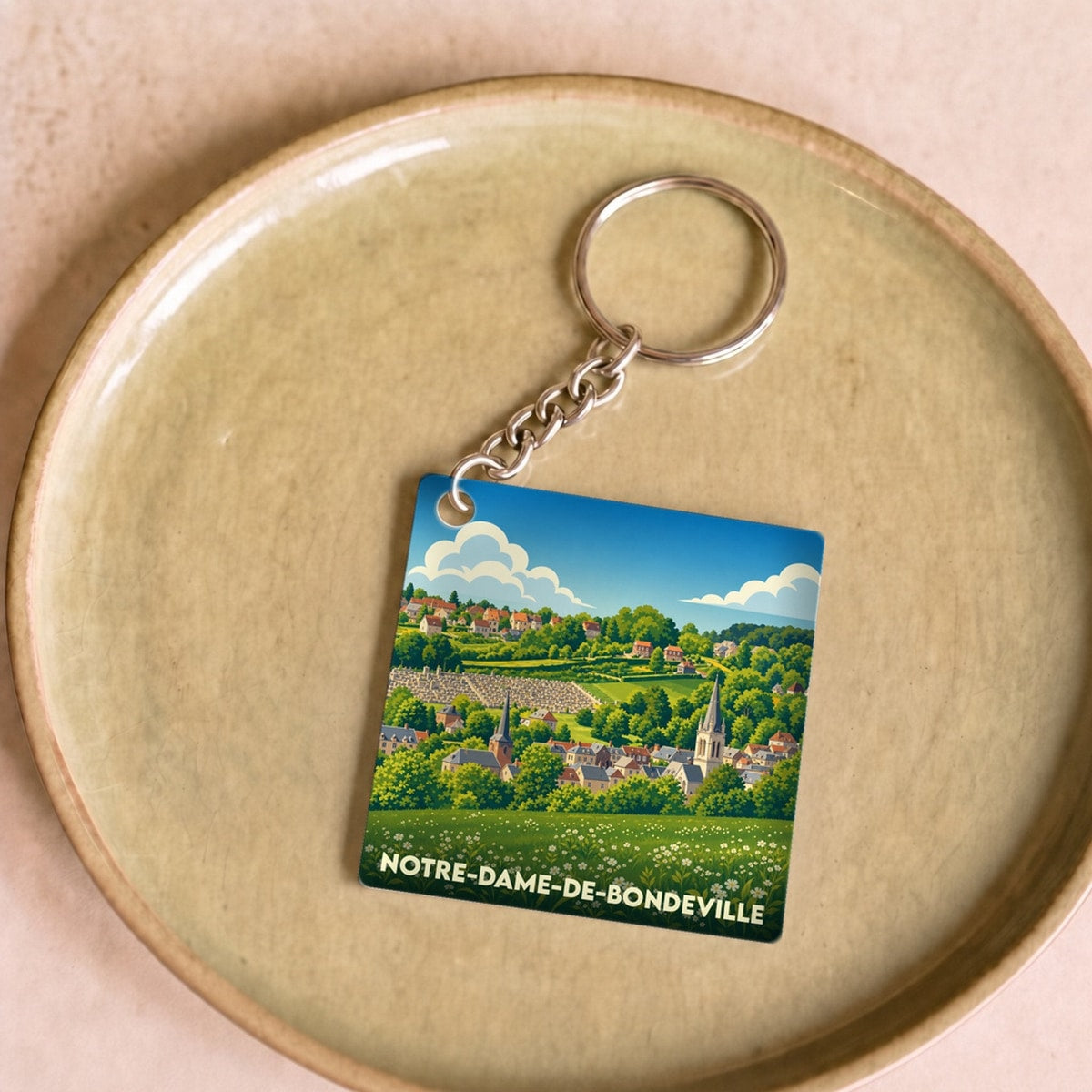 Porte-clés souvenir de la ville de Notre-Dame-de-Bondeville avec une illustration de paysage champêtre.