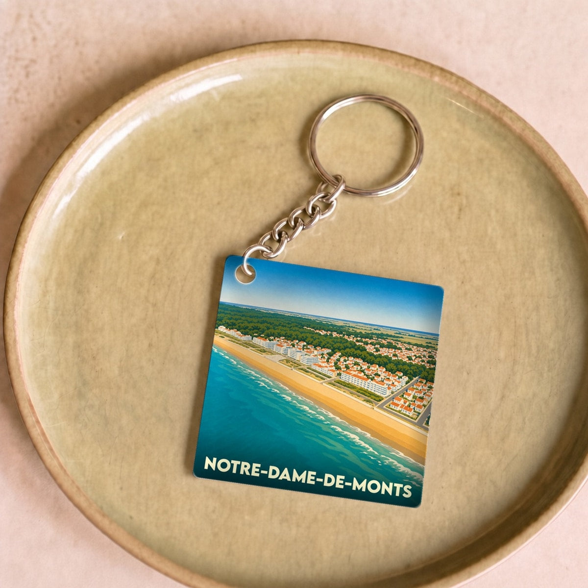 Porte-clés souvenir de la ville de Notre-Dame-de-Monts avec une illustration stylisée du littoral.