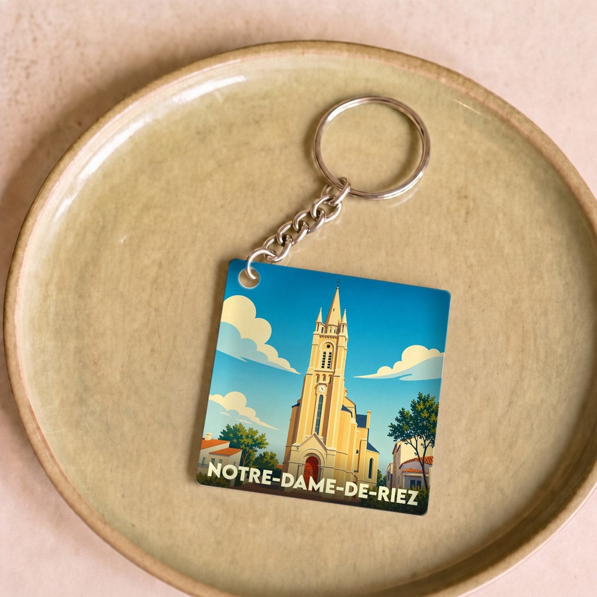 Porte-clés souvenir de la ville de Notre-Dame-de-Riez avec une illustration stylisée de son église.