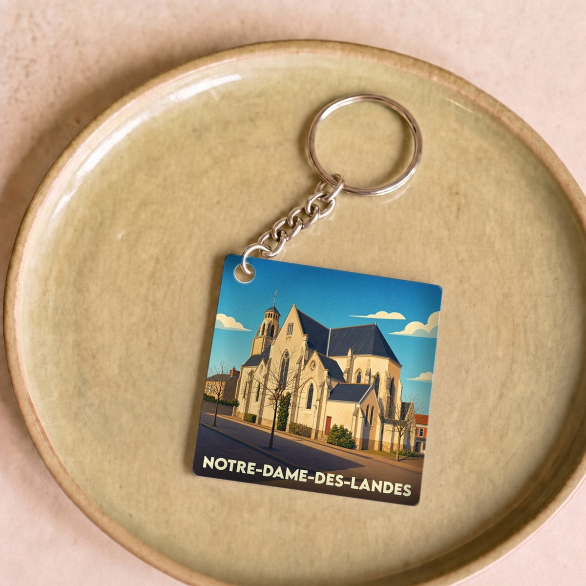 Porte-clés souvenir de la ville de Notre-Dame-des-Landes avec une illustration stylisée de son église.