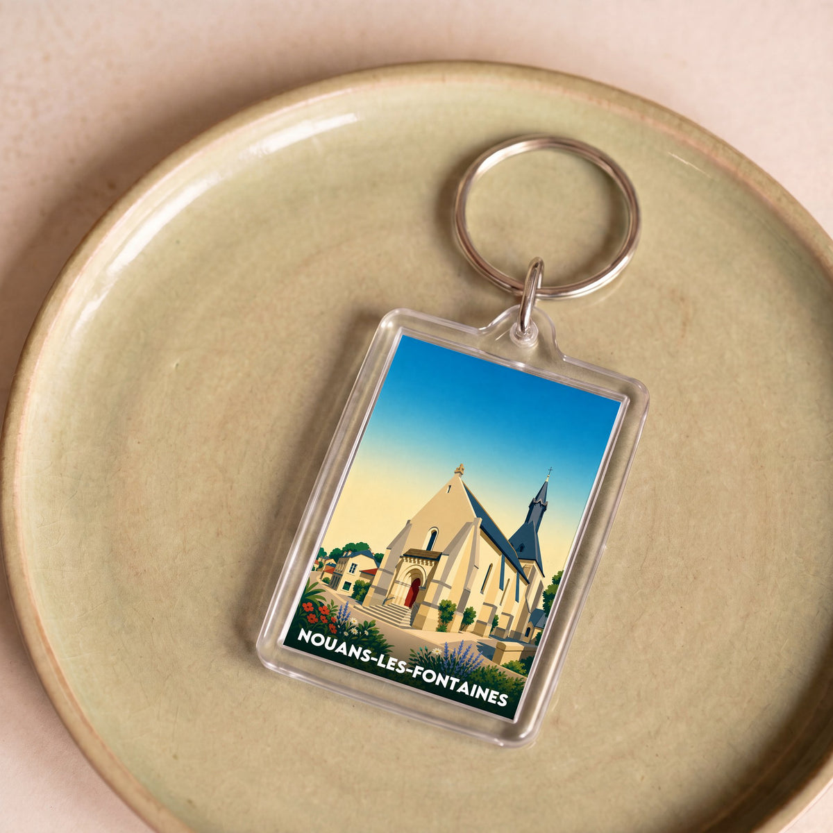 Porte-clés souvenir de la ville de Nouans-les-Fontaines avec une illustration stylisée.