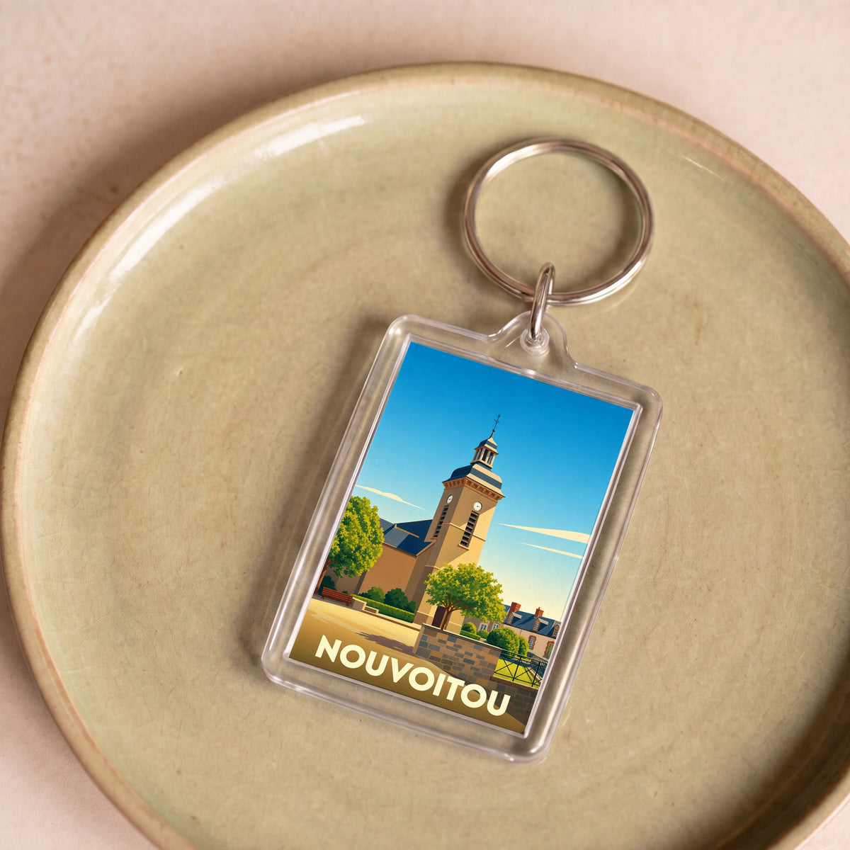 Porte-clés souvenir de la ville de Nouvoitou avec une illustration stylisée de son église.