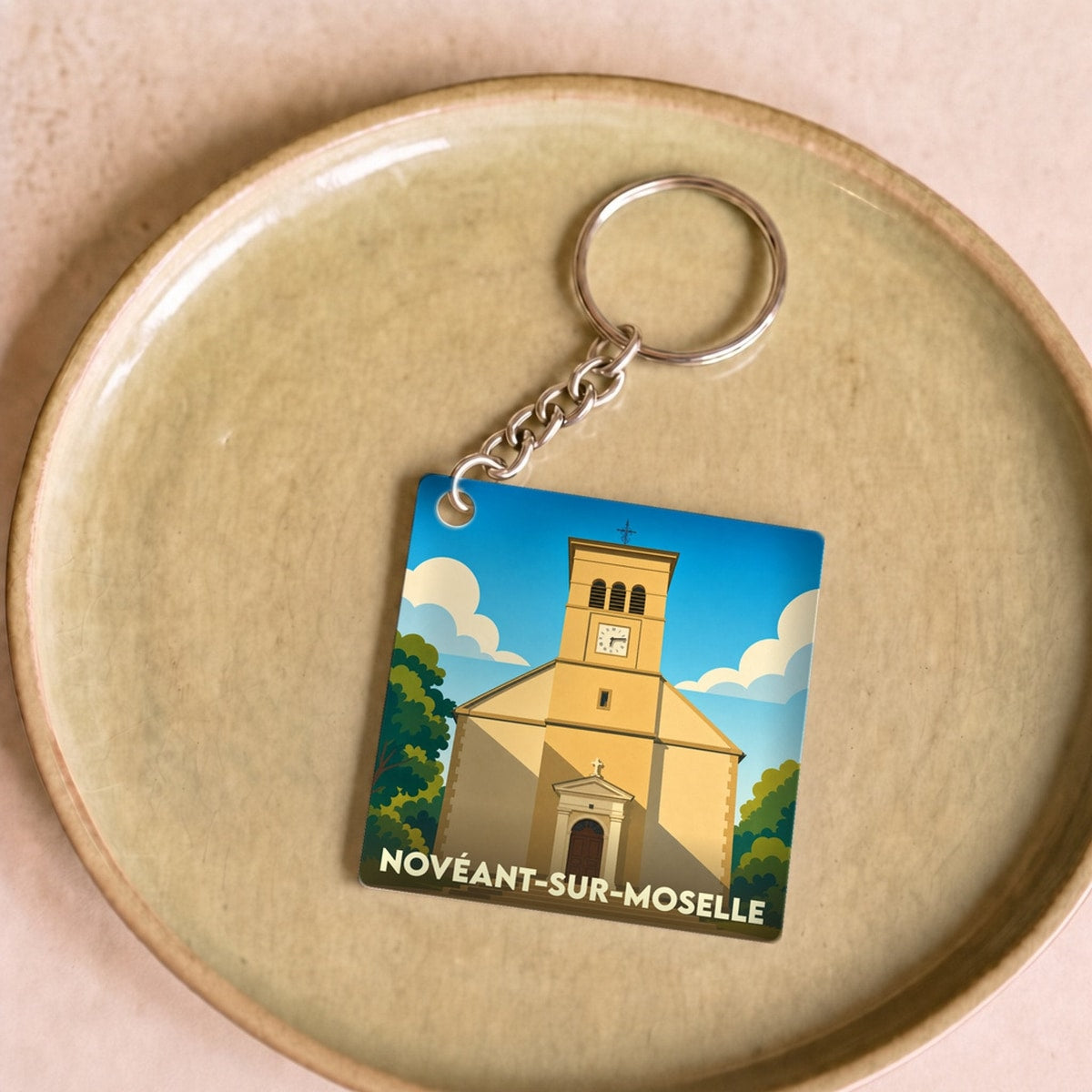 Porte-clés souvenir de la ville de Novéant-sur-Moselle avec une illustration stylisée de son église.