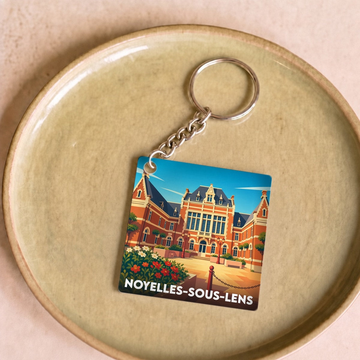 Porte-clés souvenir de la ville de Noyelles-sous-Lens avec une illustration stylisée de son patrimoine.