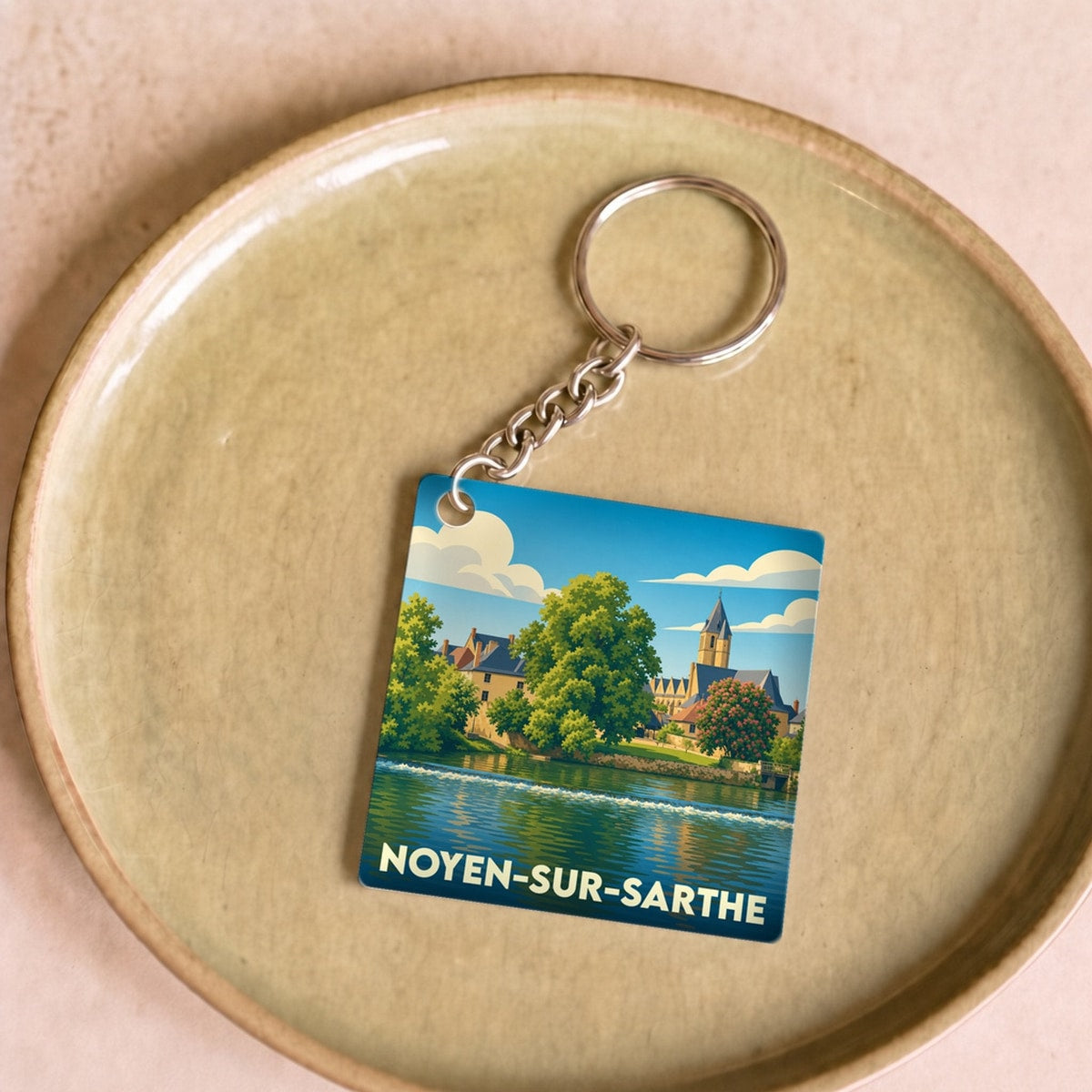 Porte-clés souvenir de la ville de Noyen-sur-Sarthe avec une illustration stylisée.