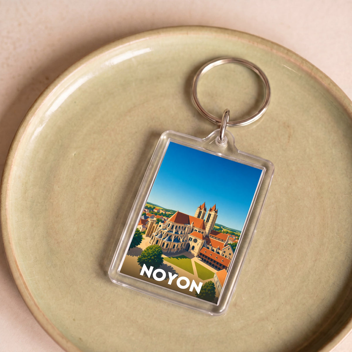 Porte-clés souvenir de la ville de Noyon avec une illustration stylisée.