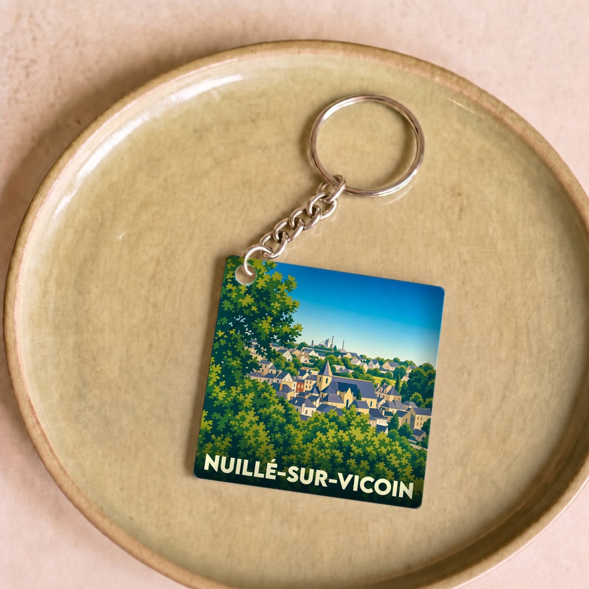 Porte-clés souvenir de la ville de Nuillé-sur-Vicoin avec une illustration stylisée.