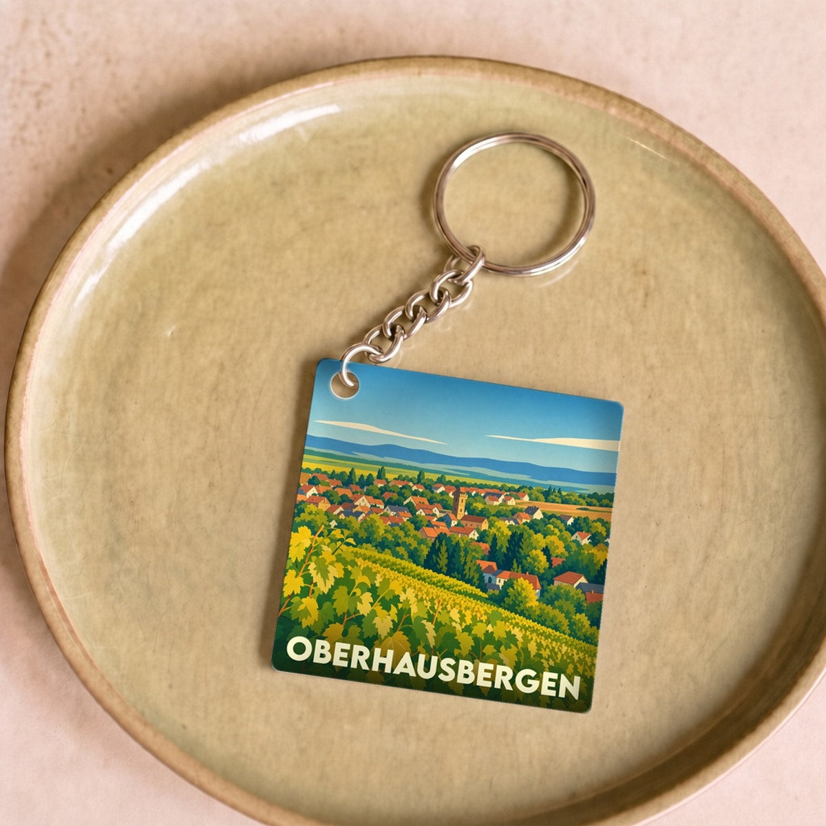 Porte-clés souvenir de la ville d'Oberhausbergen avec une illustration stylisée de vignobles.