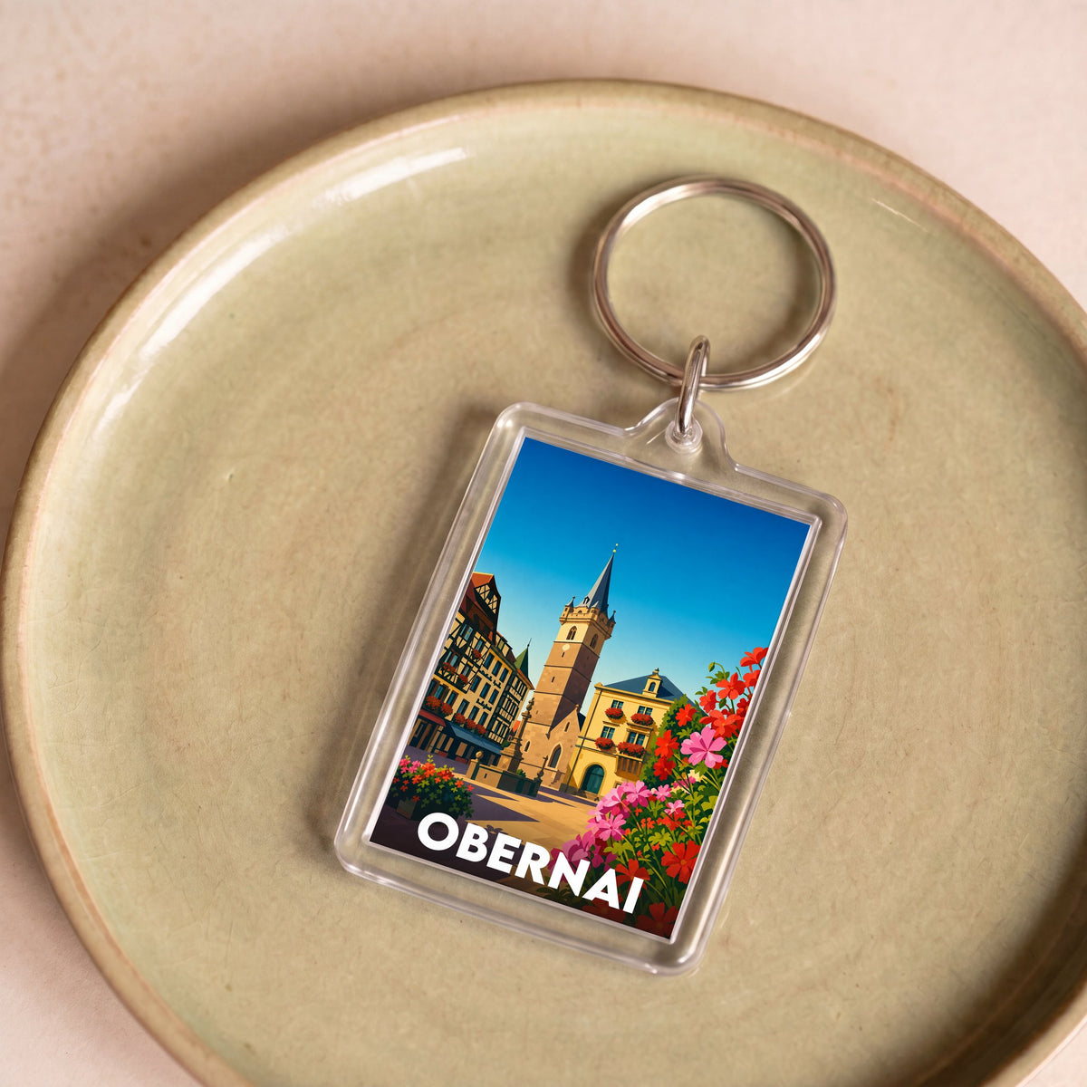 Porte-clés souvenir de la ville d'Obernai avec une illustration colorée et stylisée.