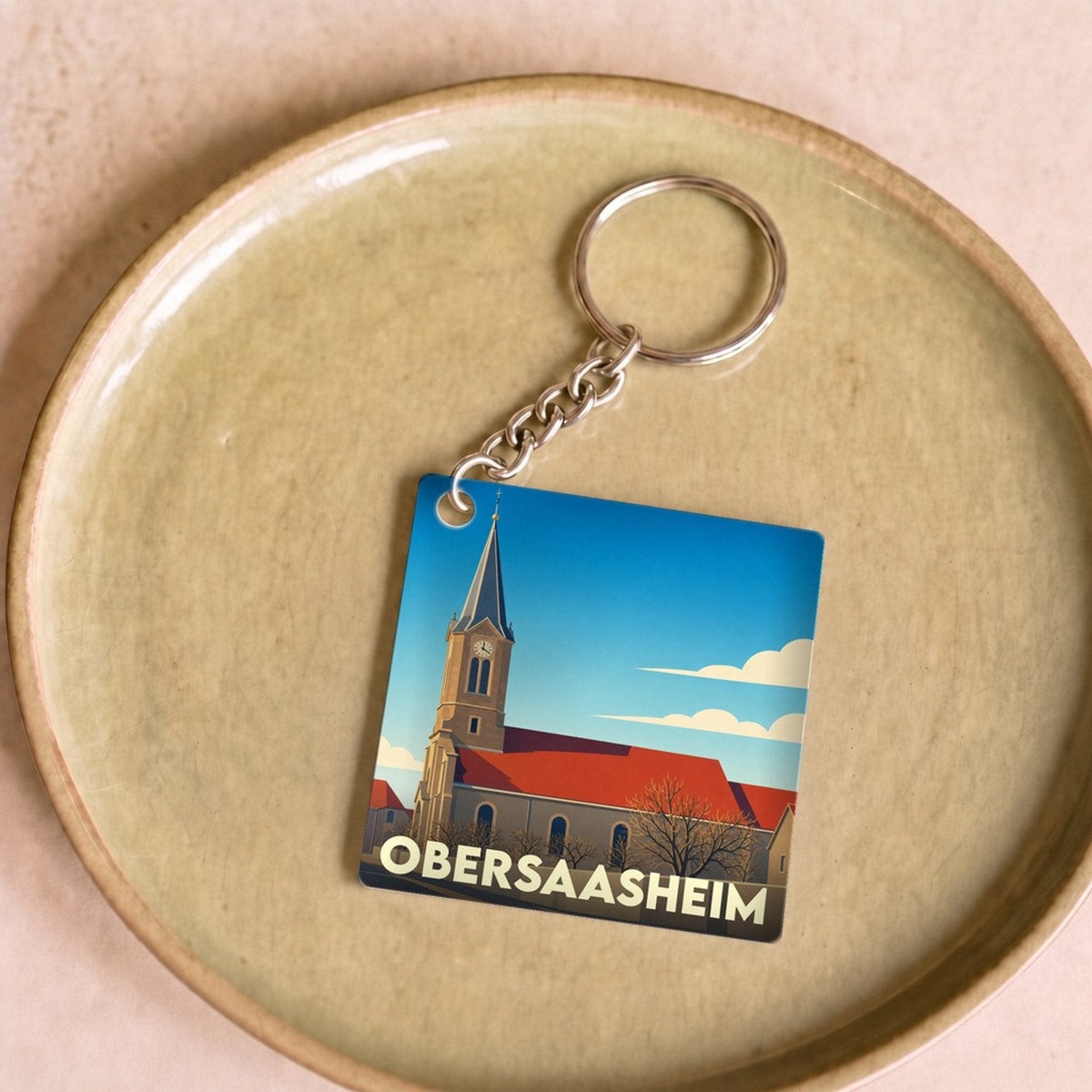 Porte-clés souvenir de la ville de Obersaasheim avec une illustration stylisée de son église.