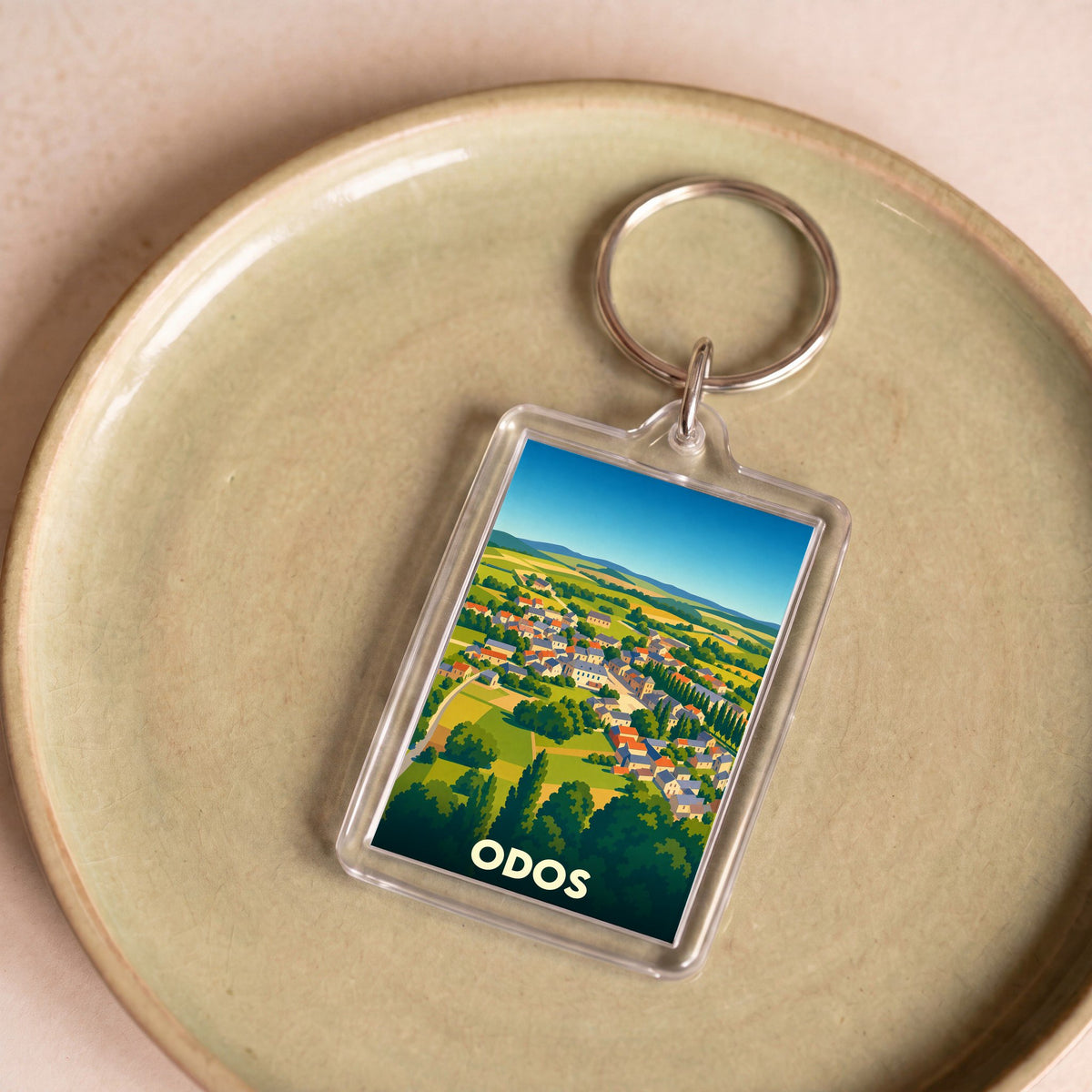 Porte-clés souvenir de la ville d'Odos avec une illustration stylisée.