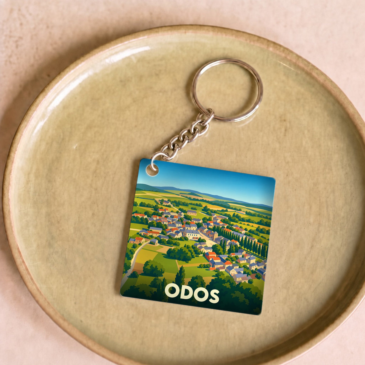 Porte-clés souvenir de la ville d'Odos avec une illustration stylisée.