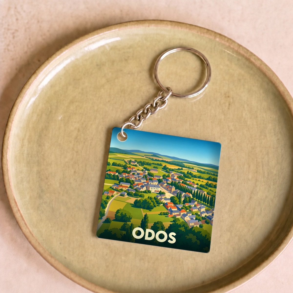 Porte-clés souvenir de la ville d'Odos avec une illustration stylisée.