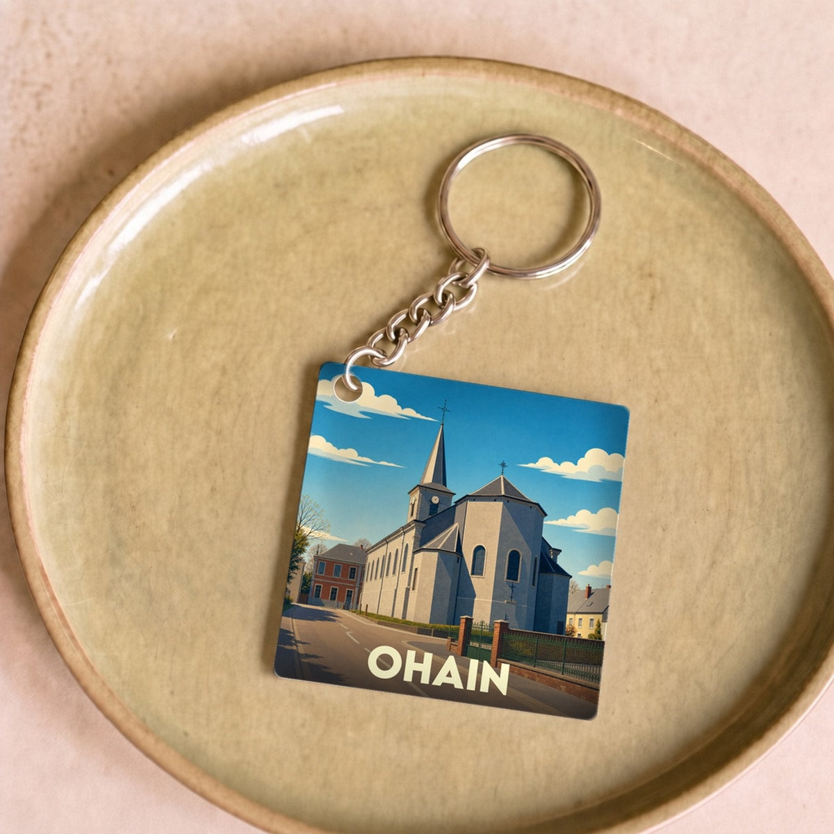 Porte-clés souvenir de la ville de Ohain avec une illustration stylisée.