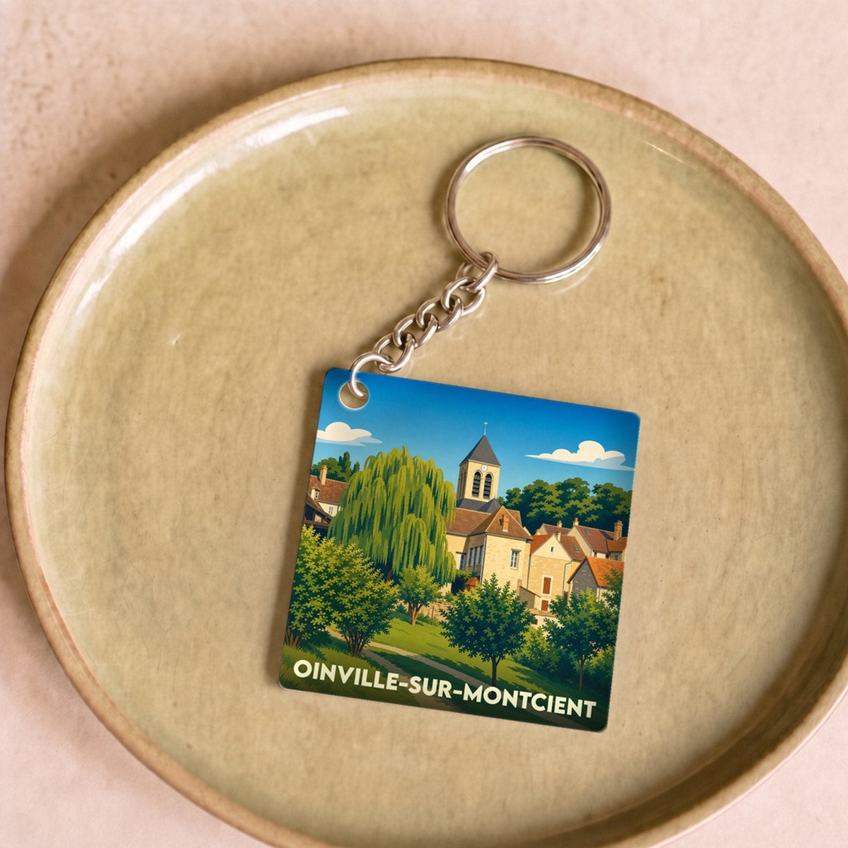 Porte-clés souvenir de la ville de Oinville-sur-Montcient avec une illustration stylisée.