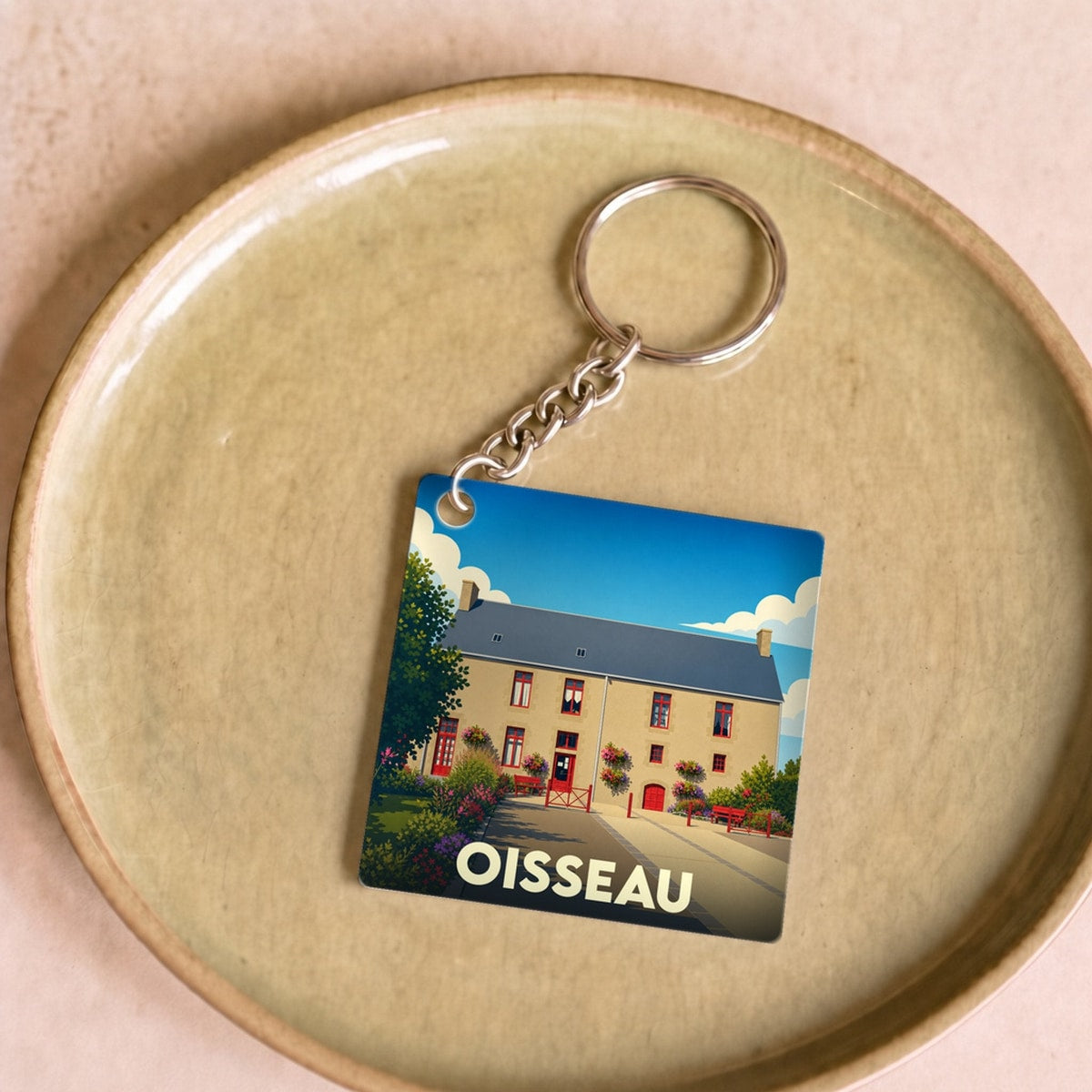 Porte-clés souvenir de la ville de Oisseau avec une illustration stylisée.