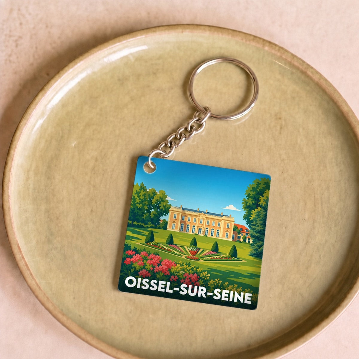 Porte-clés souvenir de la ville de Oissel-sur-Seine avec une illustration stylisée.