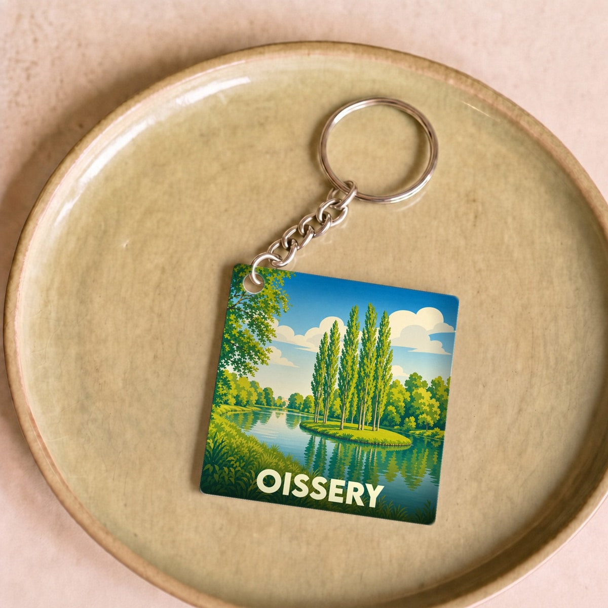 Porte-clés souvenir de la ville de Oissery avec une illustration stylisée de paysage lacustre.