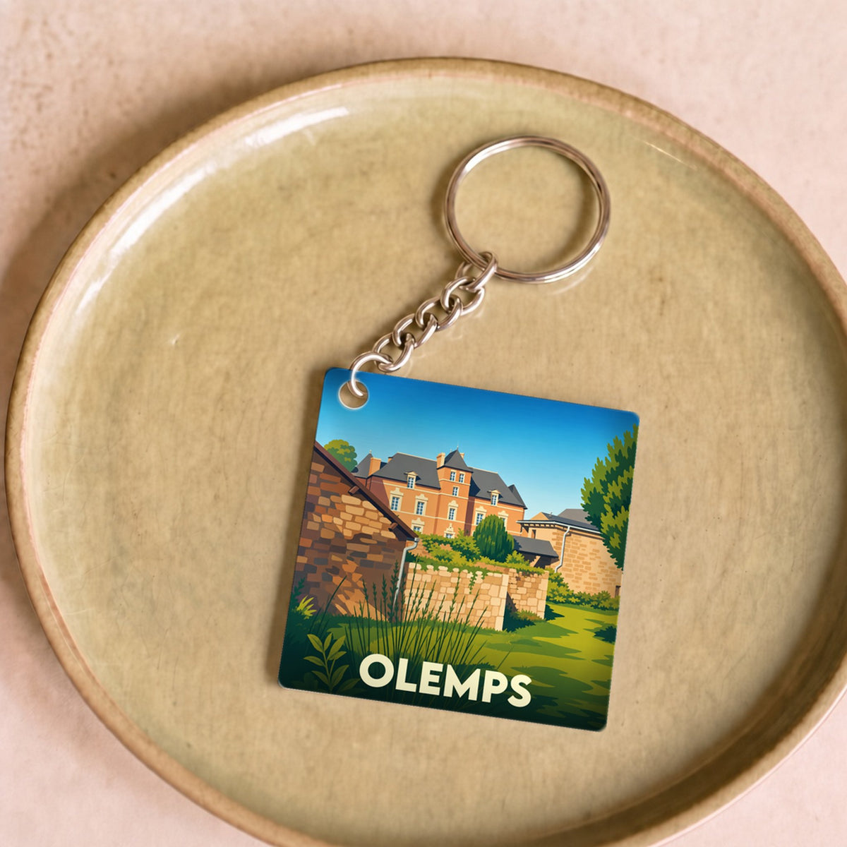 Porte-clés souvenir de la ville de Olemps avec une illustration stylisée.