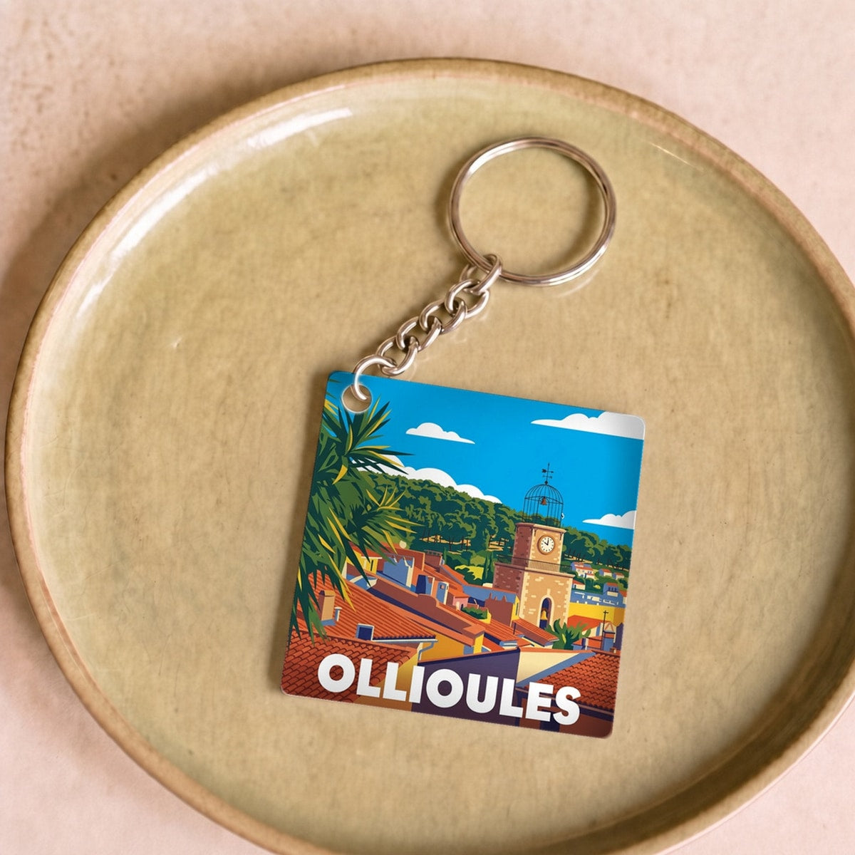 Porte-clés souvenir de la ville d'Ollioules avec une illustration stylisée et colorée.