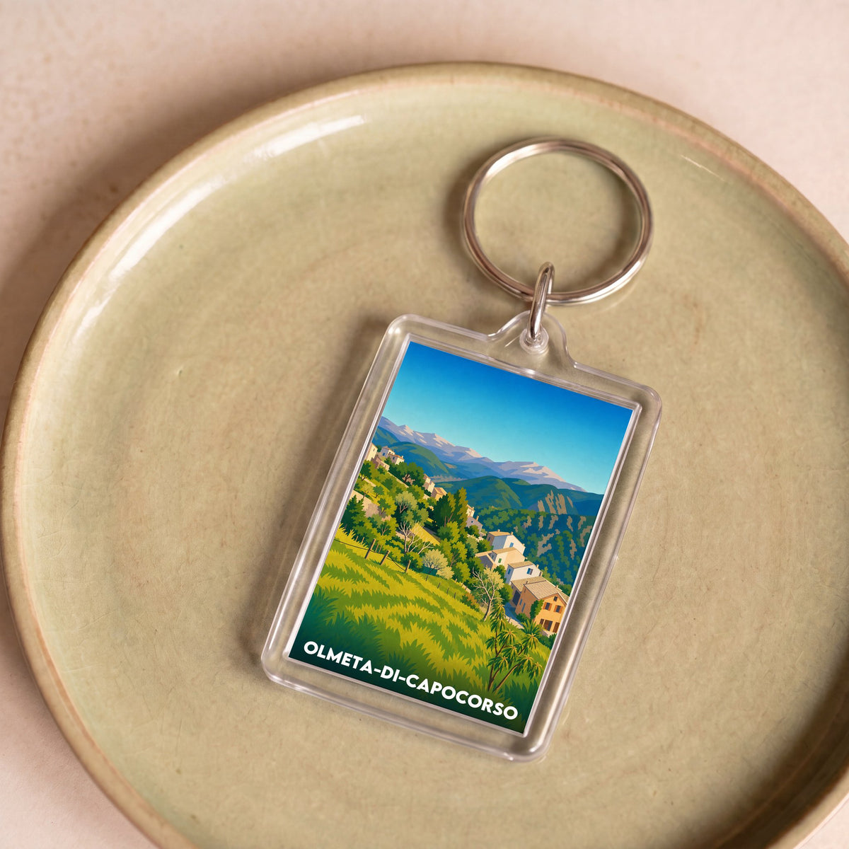 Porte-clés souvenir de la ville d'Olmeta-di-Capocorso avec une illustration stylisée.