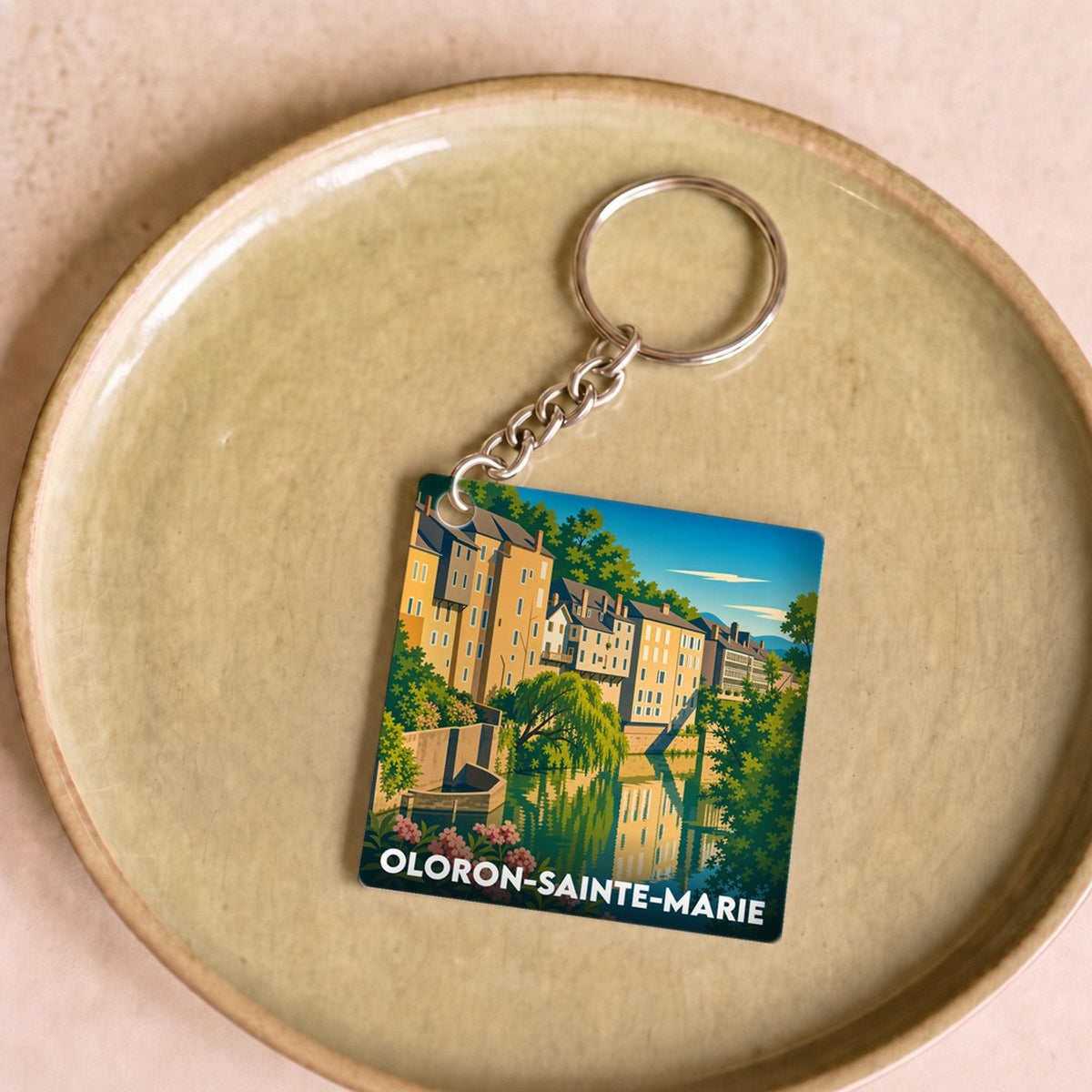 Porte-clés souvenir de la ville de Oloron-Sainte-Marie avec une illustration stylisée.