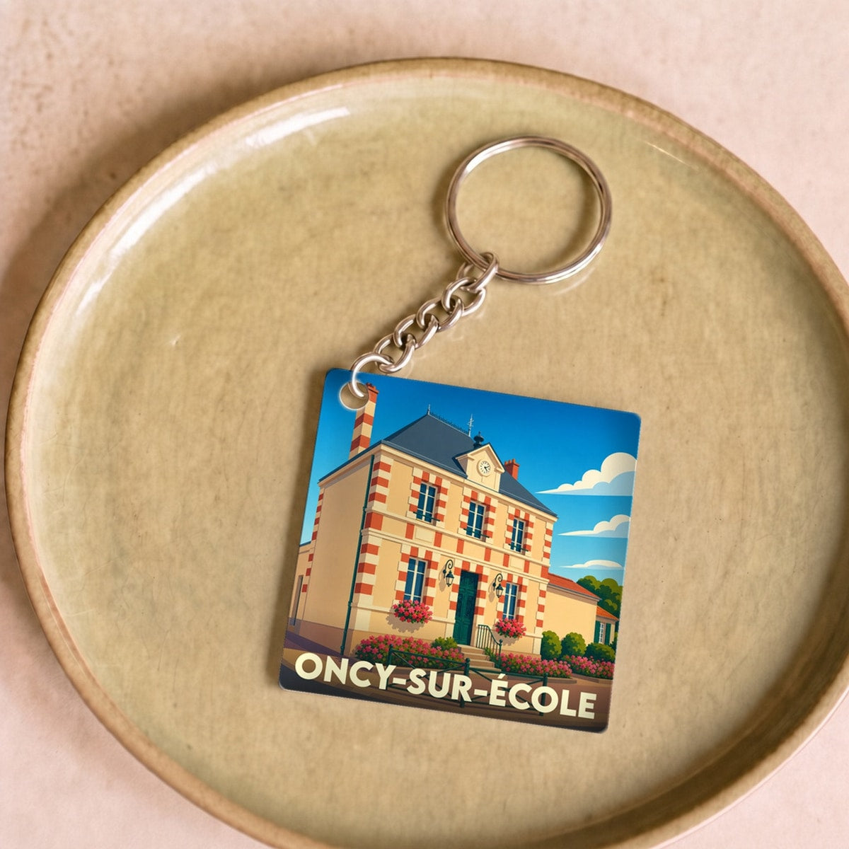 Porte-clés souvenir de la ville de Oncy-sur-École avec une illustration stylisée de sa mairie.