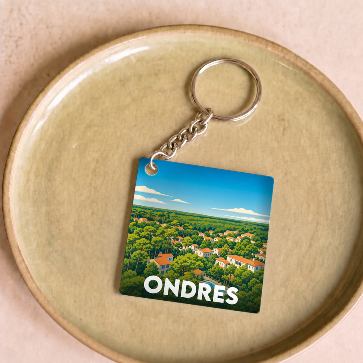 Porte-clés souvenir de la ville d'Ondres avec une illustration stylisée d'un paysage arboré.