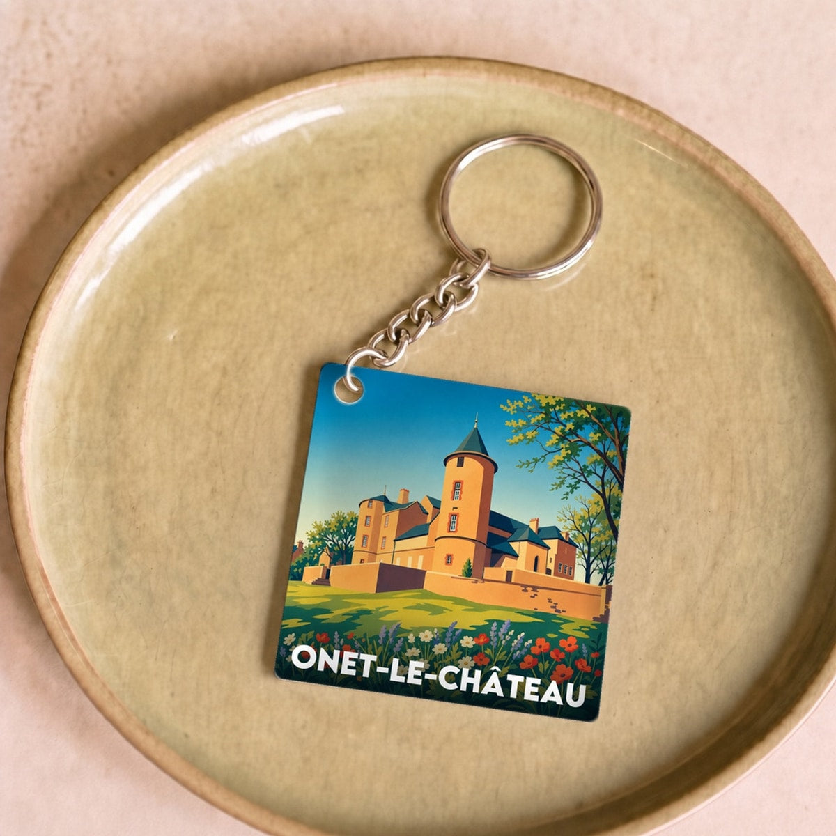 Porte-clés souvenir de la ville de Onet-le-Château avec une illustration stylisée de son château.