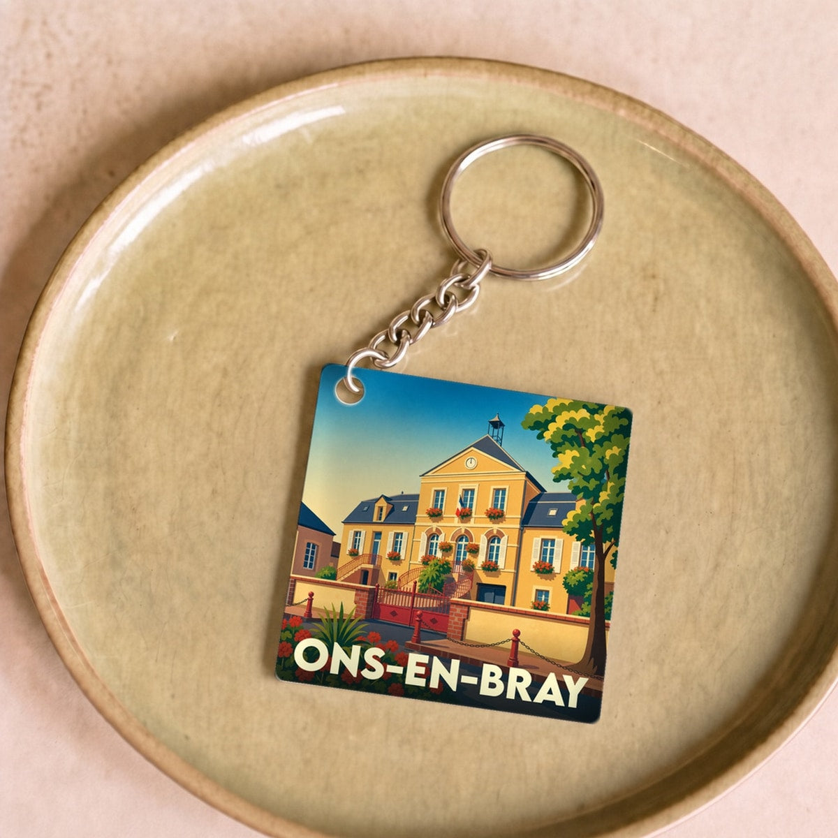 Porte-clés souvenir de la ville de Ons-en-Bray avec une illustration stylisée de sa mairie.