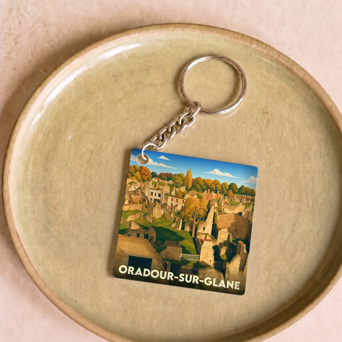 Porte-clés souvenir de la ville d'Oradour-sur-Glane avec une illustration stylisée de ses ruines historiques.