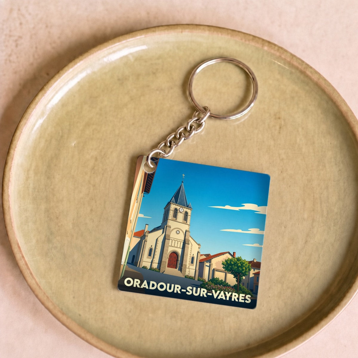 Porte-clés souvenir de la ville d'Oradour-sur-Vayres avec une illustration stylisée de son église.