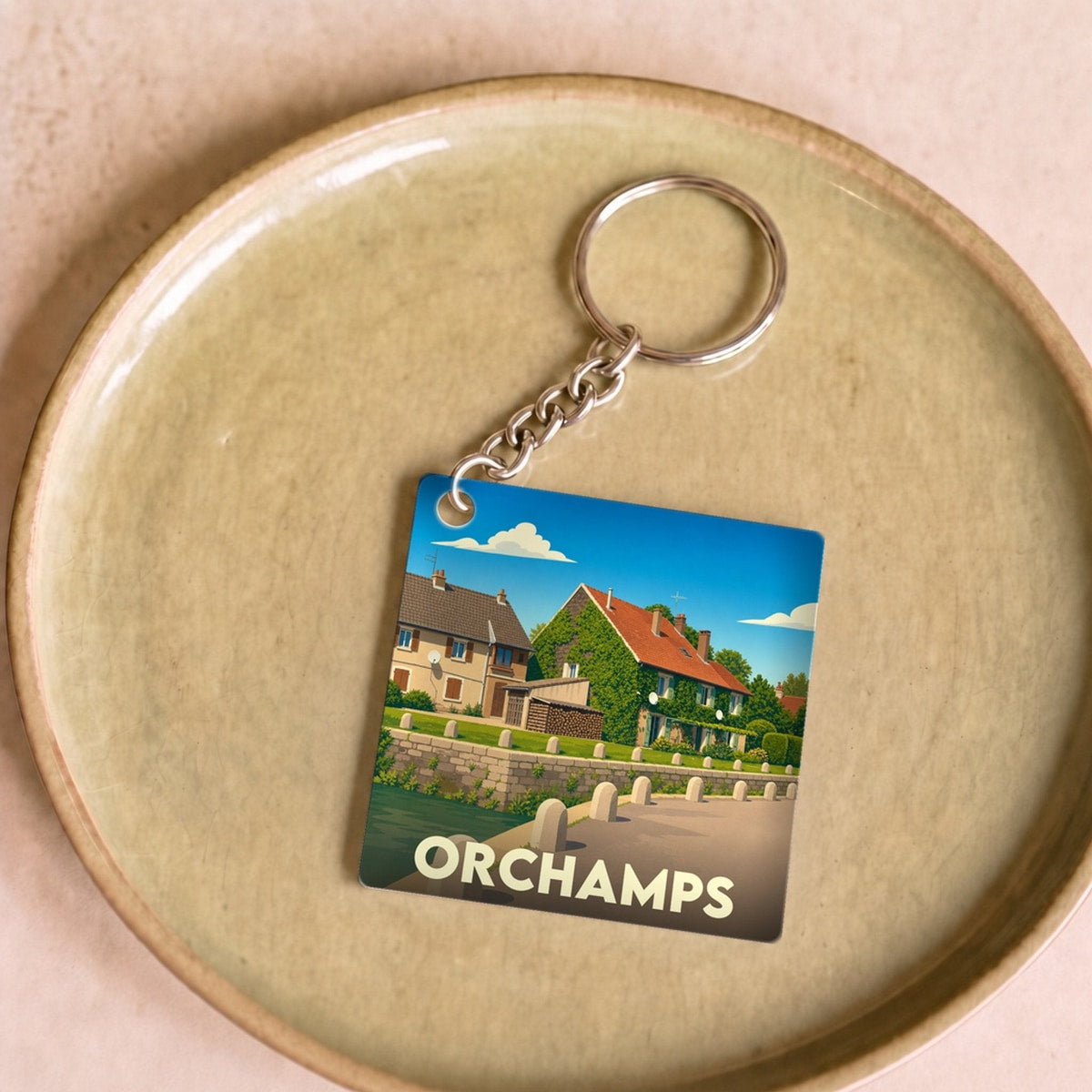 Porte-clés souvenir de la ville d'Orchamps avec une illustration stylisée.