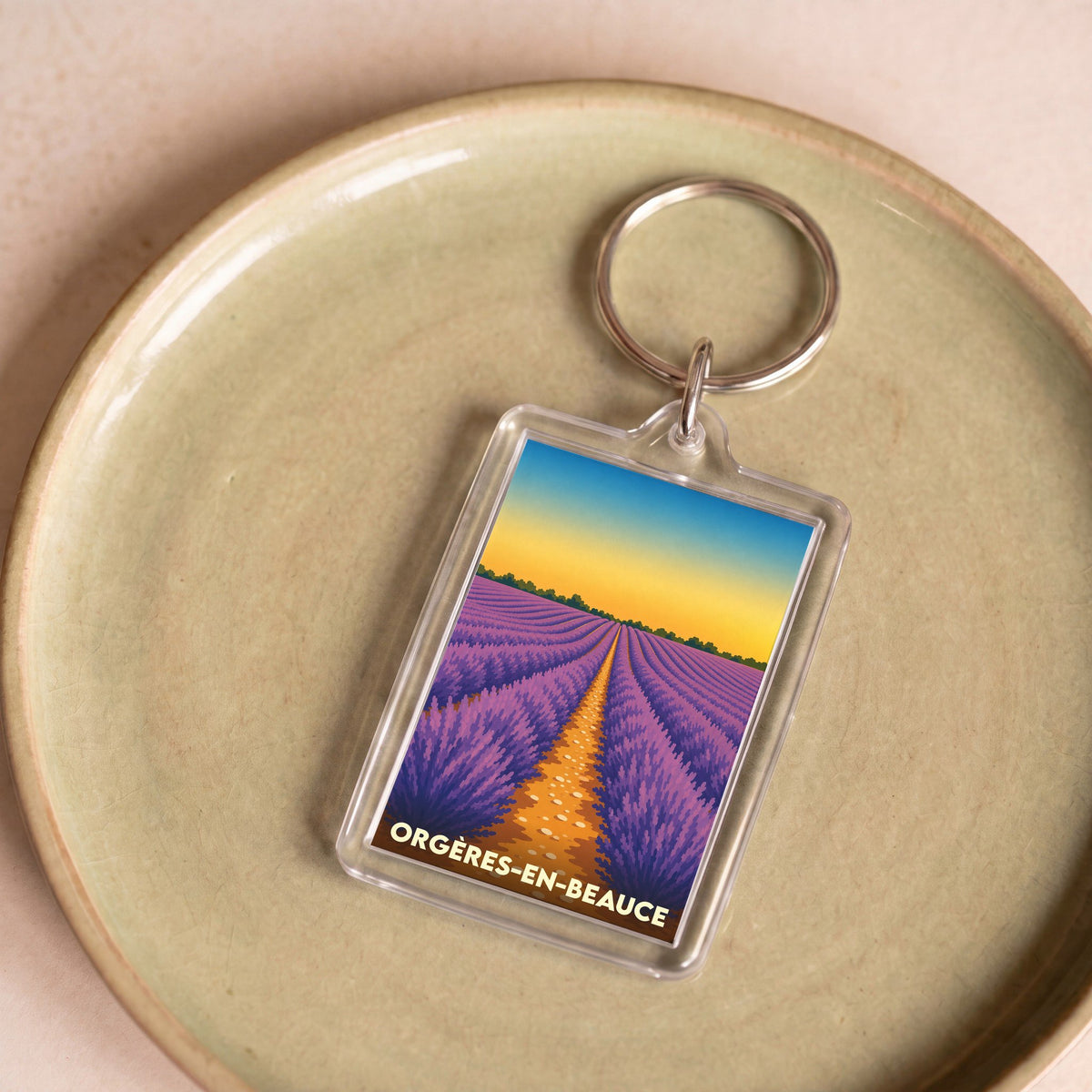 Porte-clés souvenir de la ville d'Orgères-en-Beauce avec une illustration stylisée d'un champ de lavande au coucher du soleil.