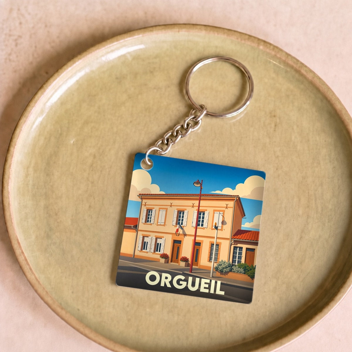 Porte-clés souvenir de la ville d'Orgueil avec une illustration stylisée.