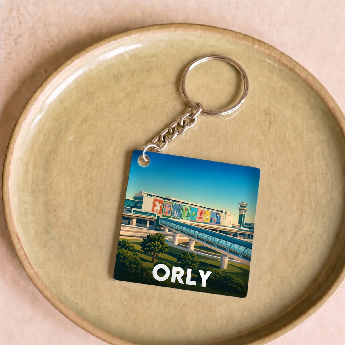 Porte-clés souvenir de la ville de Orly avec une illustration stylisée.