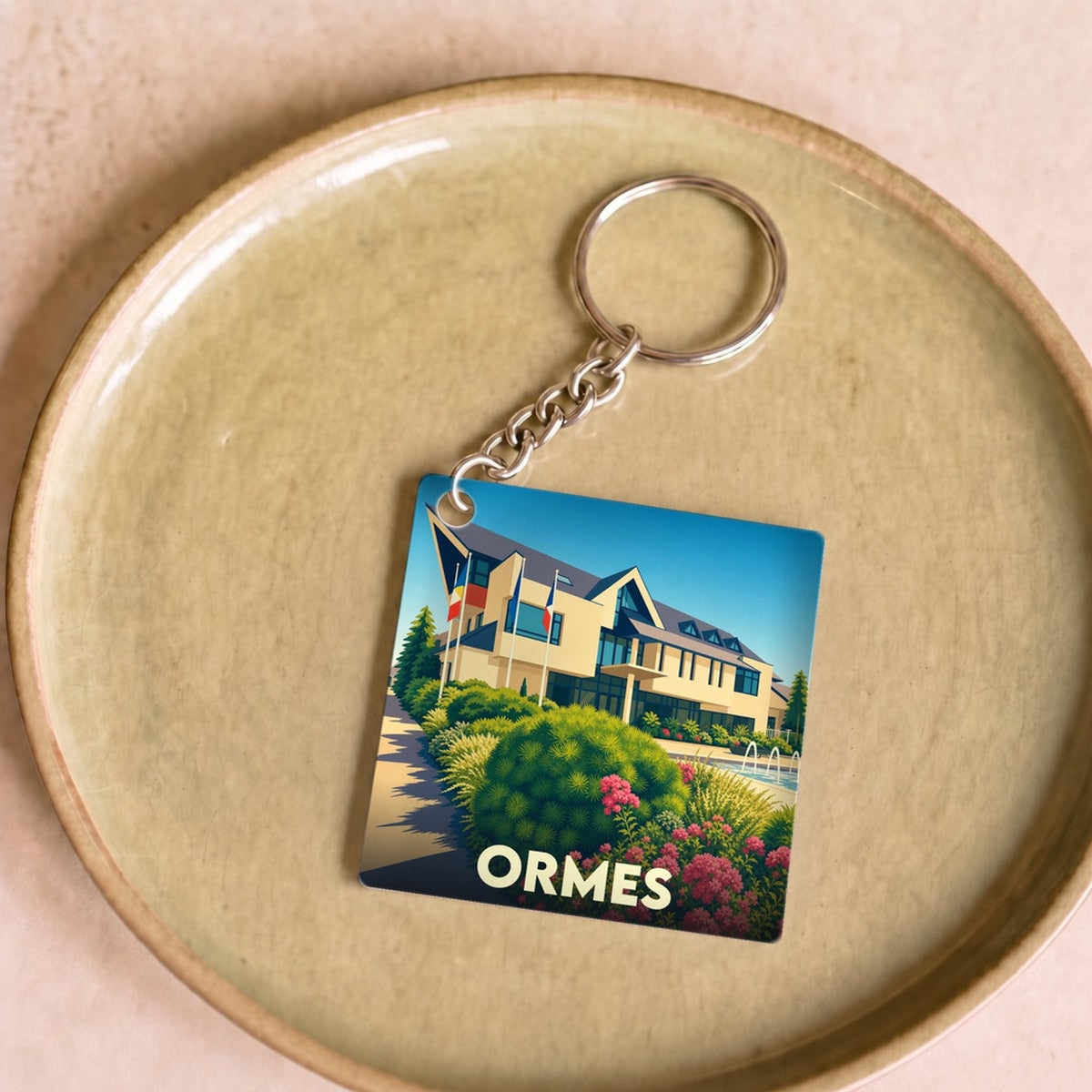 Porte-clés souvenir de la ville d'Ormes avec une illustration stylisée de son hôtel de ville.