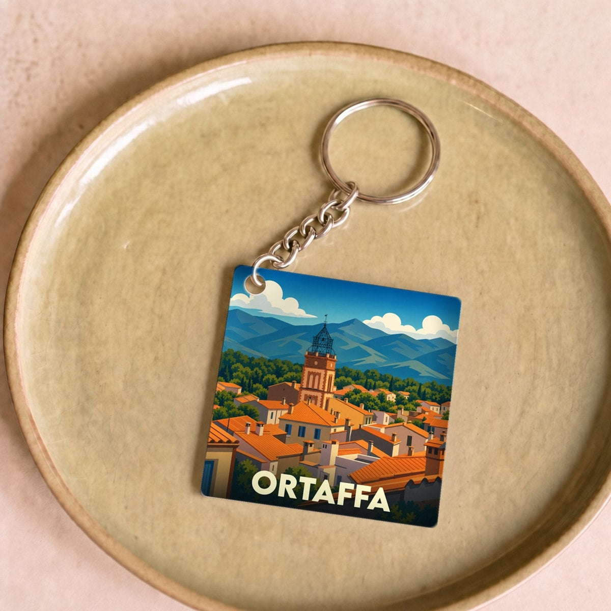 Porte-clés souvenir de la ville d'Ortaffa avec une illustration stylisée.