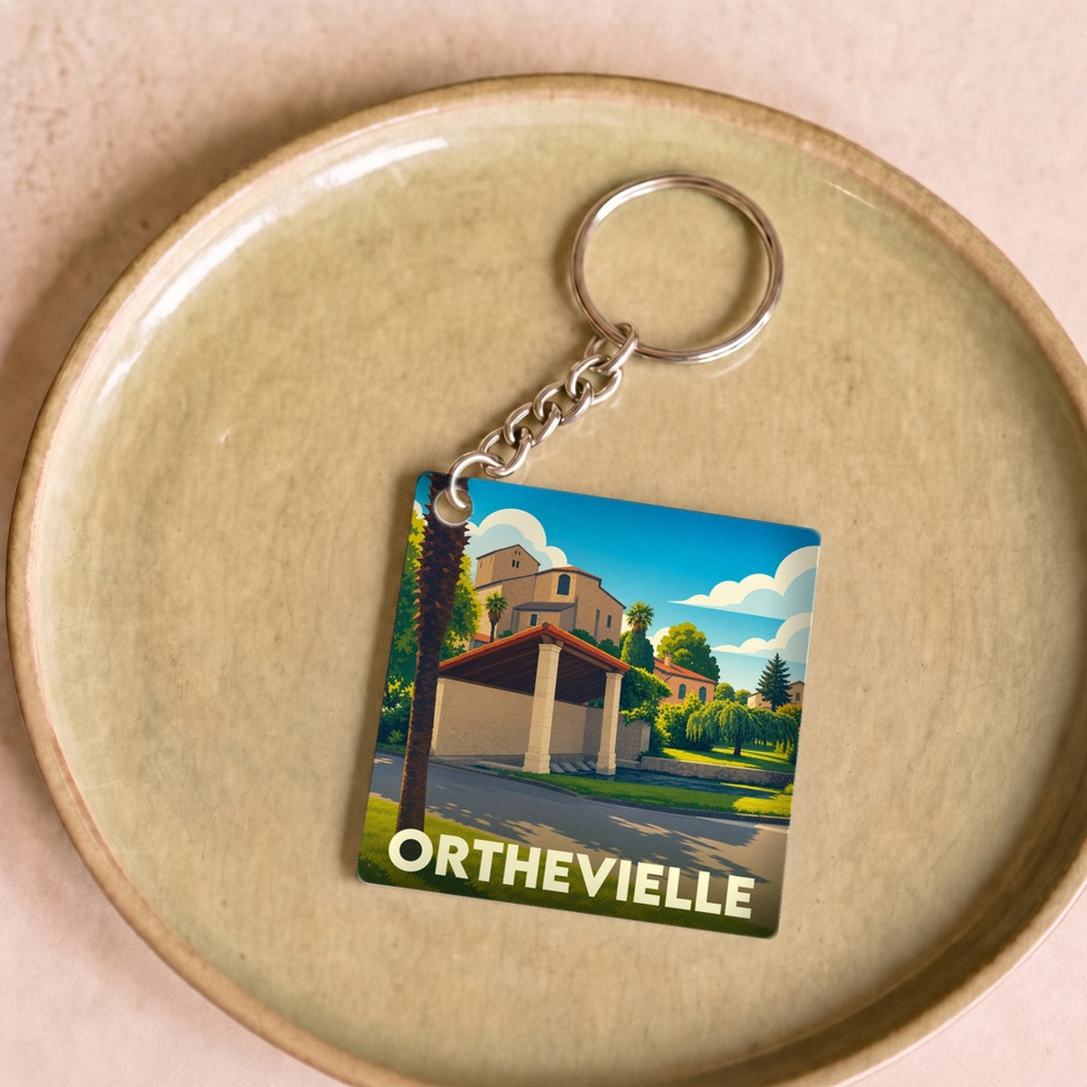 Porte-clés souvenir de la ville d'Orthevielle avec une illustration stylisée.