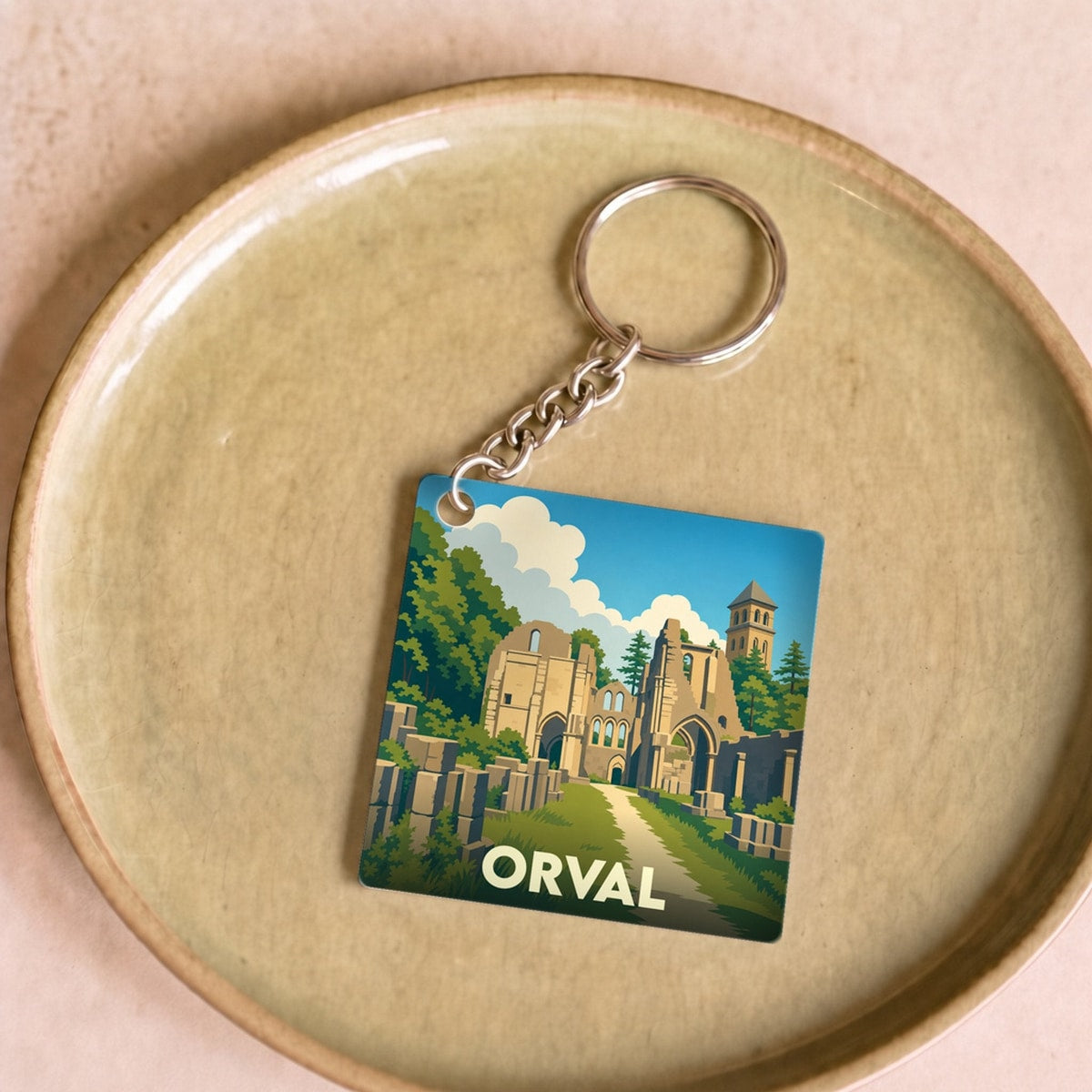 Porte-clés souvenir de la ville de Orval avec une illustration stylisée de son abbaye en ruines.