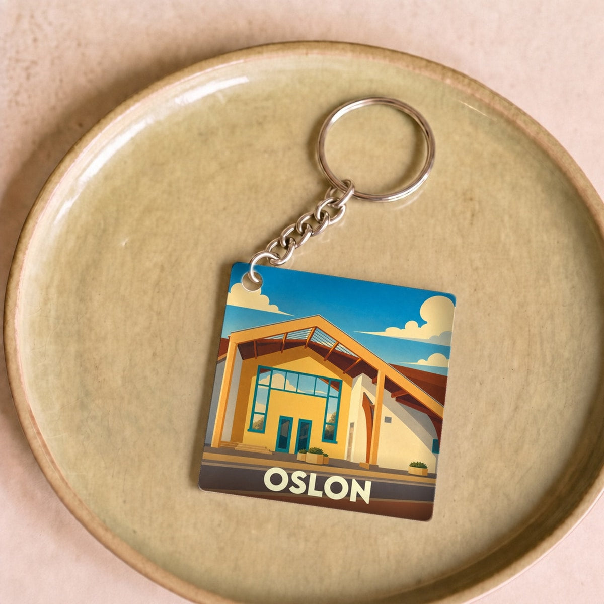 Porte-clés souvenir de la ville d'Oslon avec une illustration stylisée.