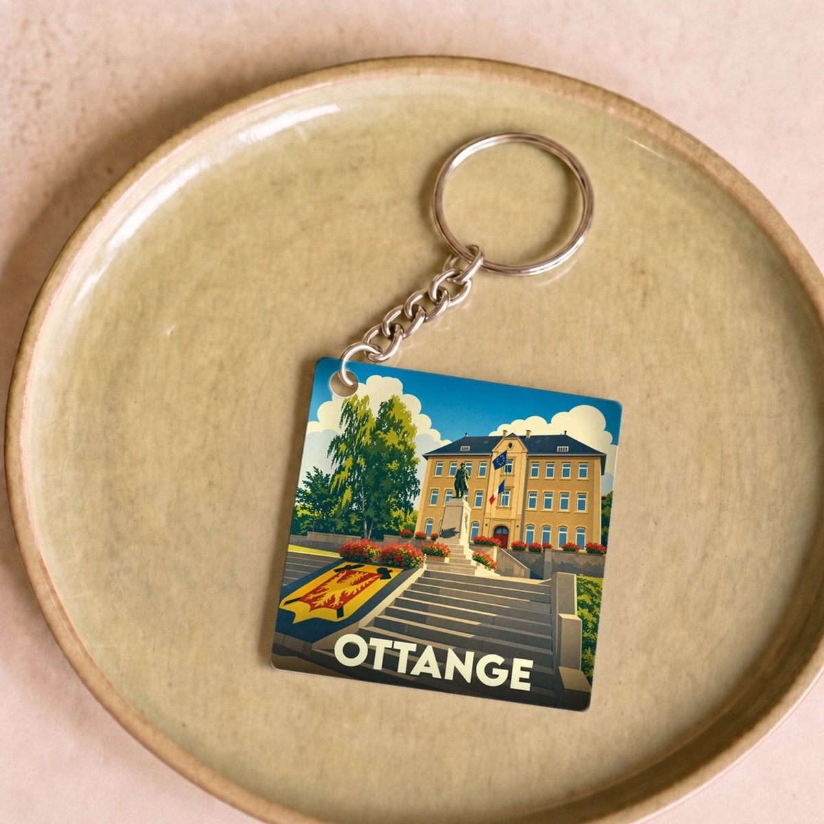 Porte-clés souvenir de la ville d'Ottange avec une illustration stylisée de son hôtel de ville.