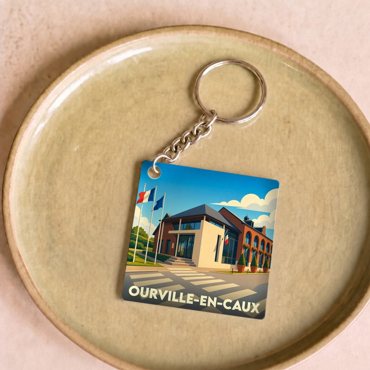 Porte-clés souvenir de la ville de Ourville-en-Caux avec une illustration stylisée de la mairie.