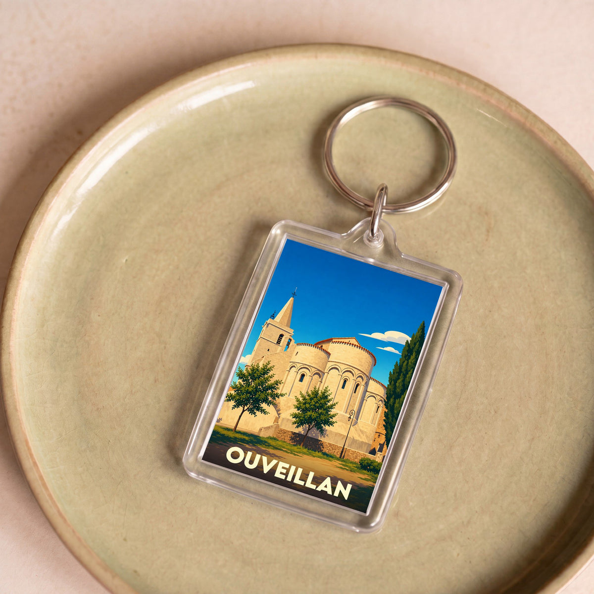 Porte-clés souvenir de la ville d'Ouveillan avec une illustration stylisée de son église.