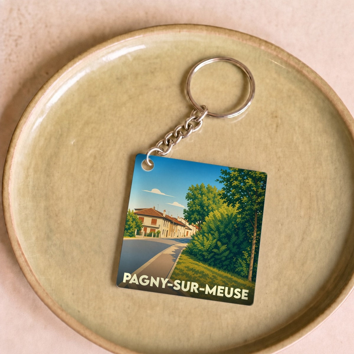 Porte-clés souvenir de la ville de Pagny-sur-Meuse avec une illustration stylisée.