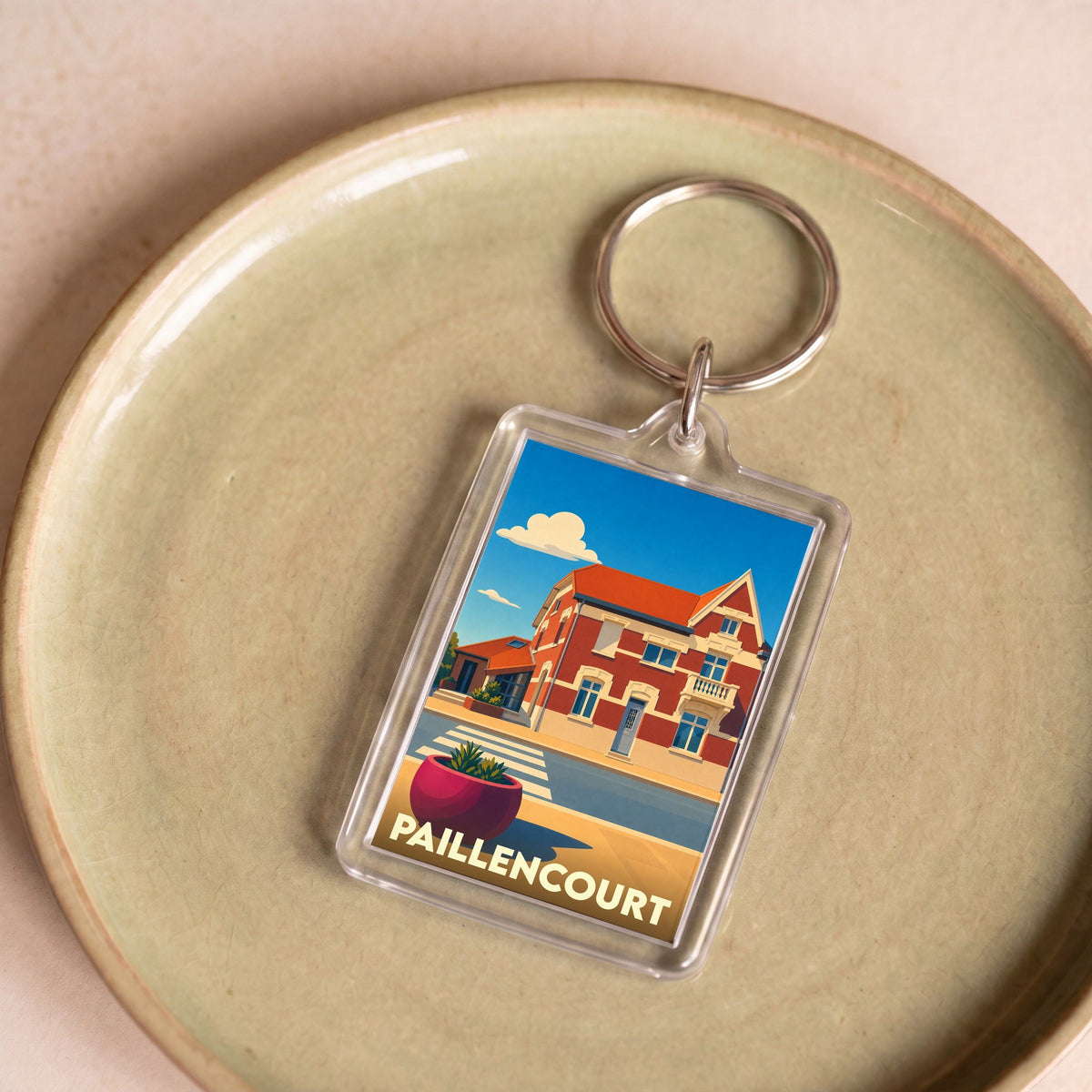 Porte-clés souvenir de la ville de Paillencourt avec une illustration stylisée.