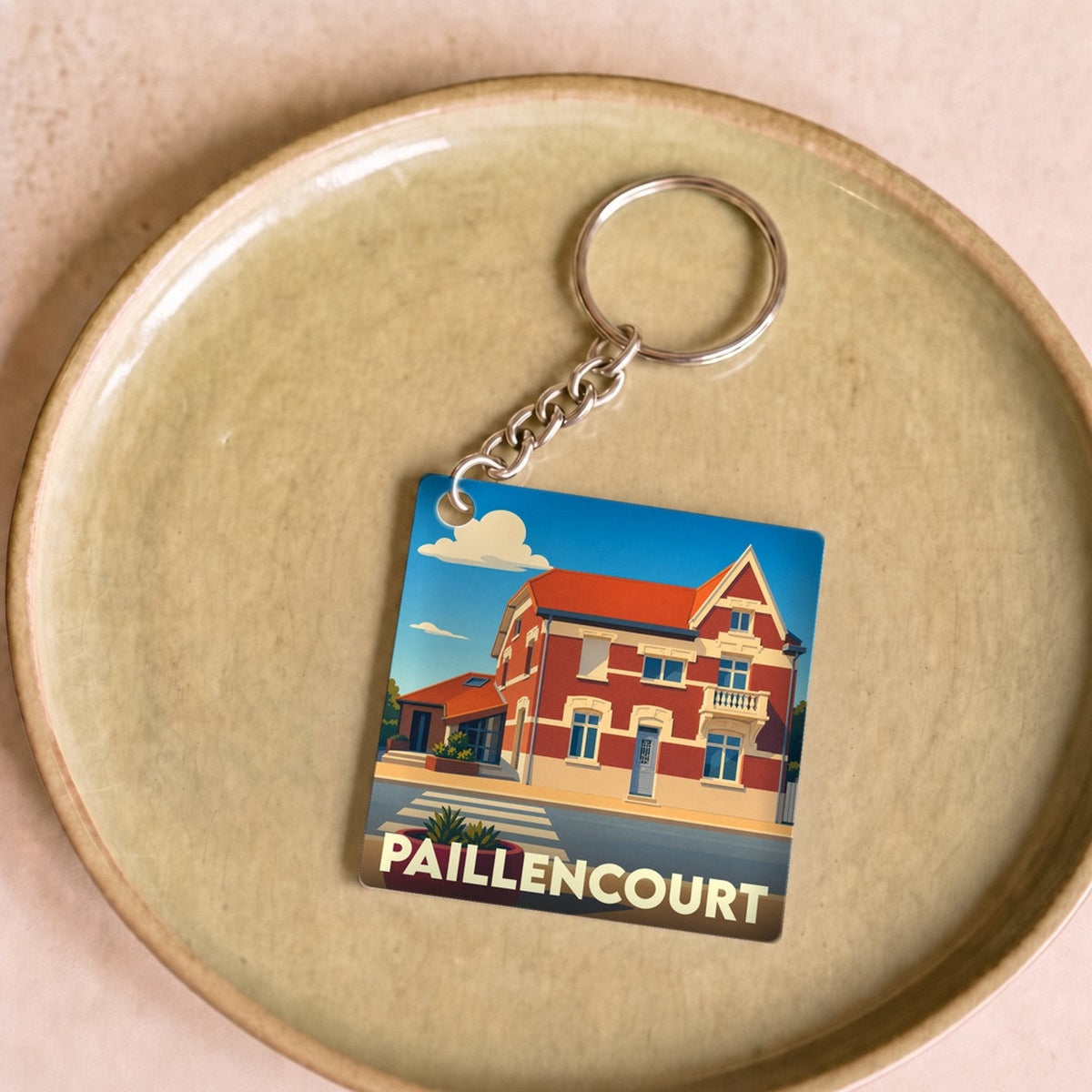 Porte-clés souvenir de la ville de Paillencourt avec une illustration stylisée.