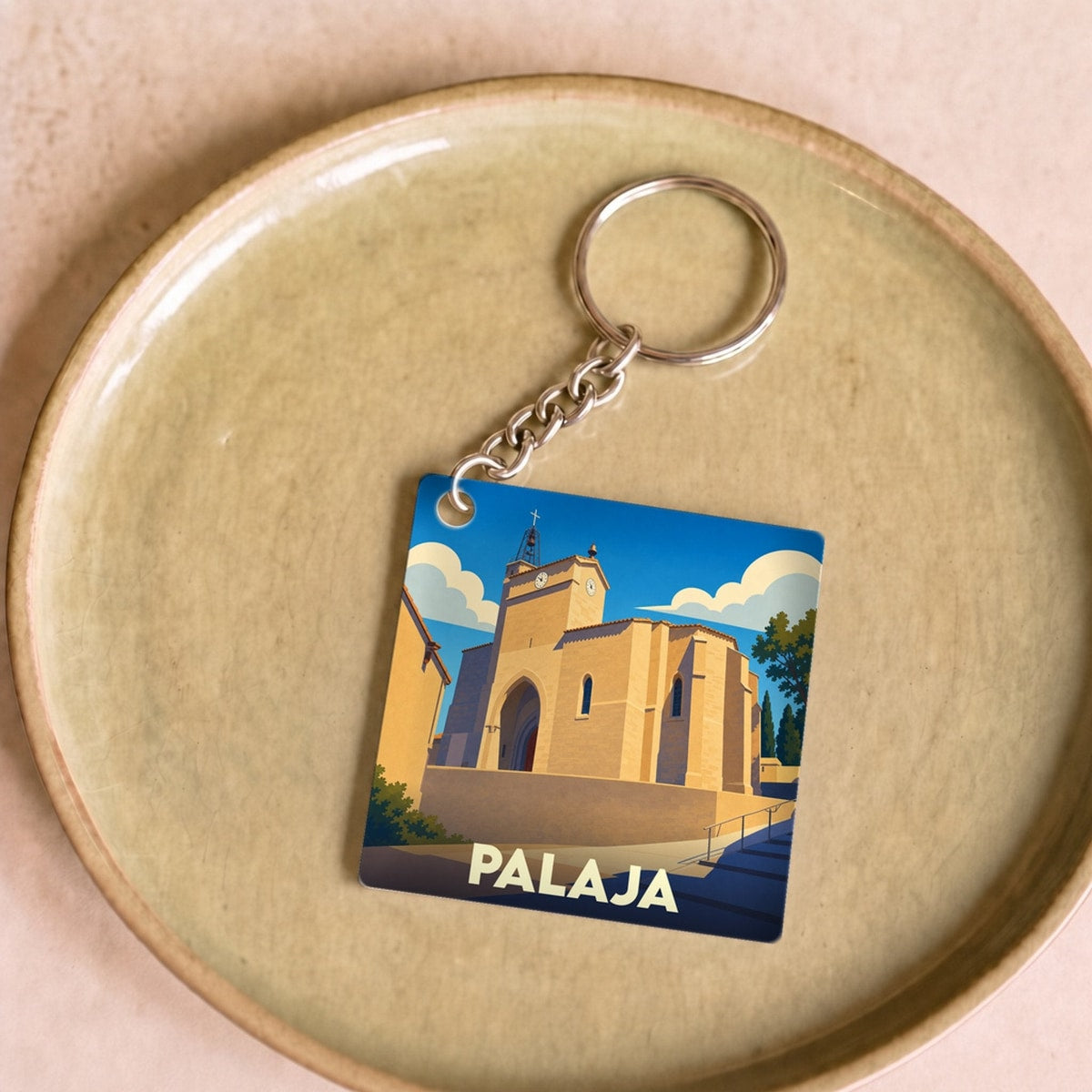 Porte-clés souvenir de la ville de Palaja avec une illustration stylisée de son église.