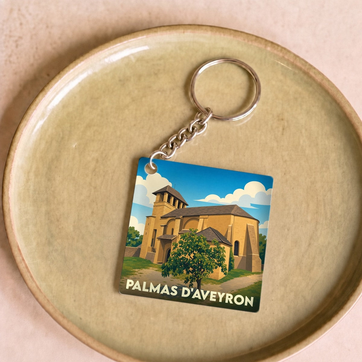 Porte-clés souvenir de la ville de Palmas d'Aveyron avec une illustration stylisée de son église.